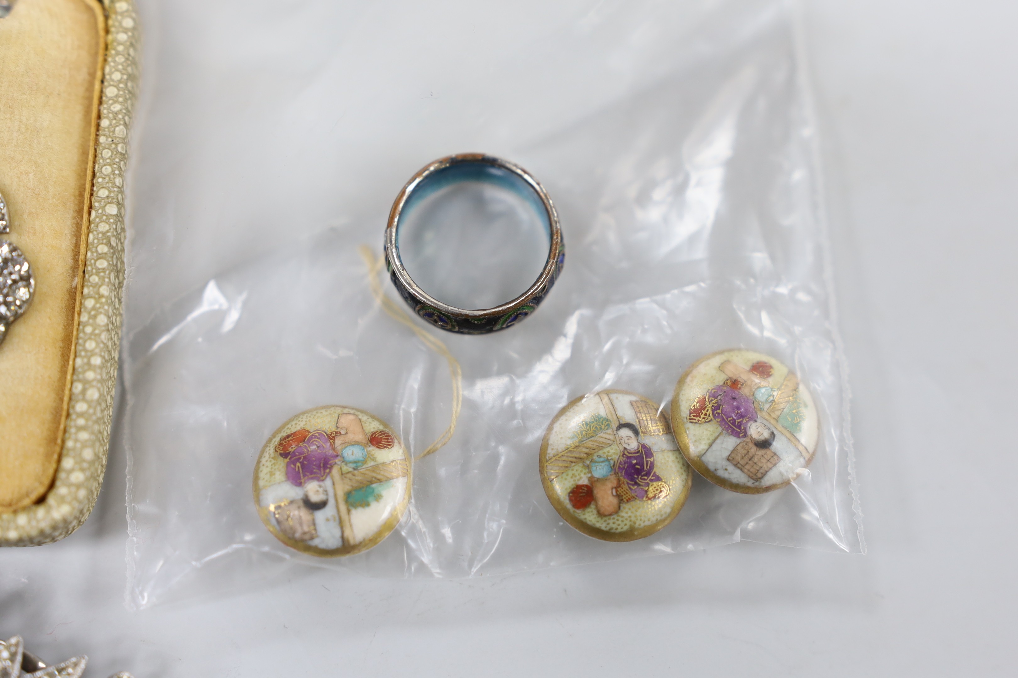 A small group of white metal and paste set jewellery, including a double clip brooch, necklace and three pairs of earrings, three satsuma buttons and a cloisonne ring.
